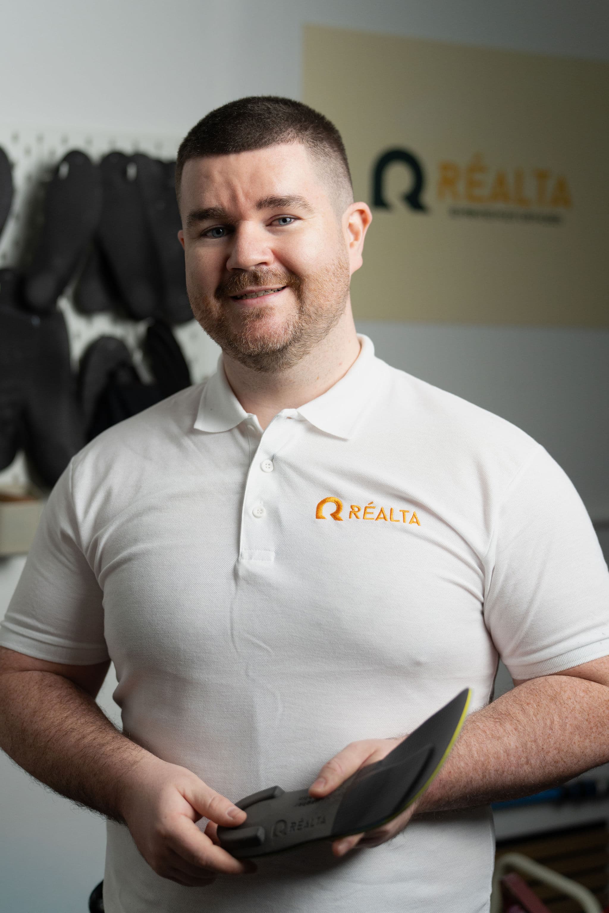 Paul McMullan, founder of Réalta Labs, holding a custom orthotic