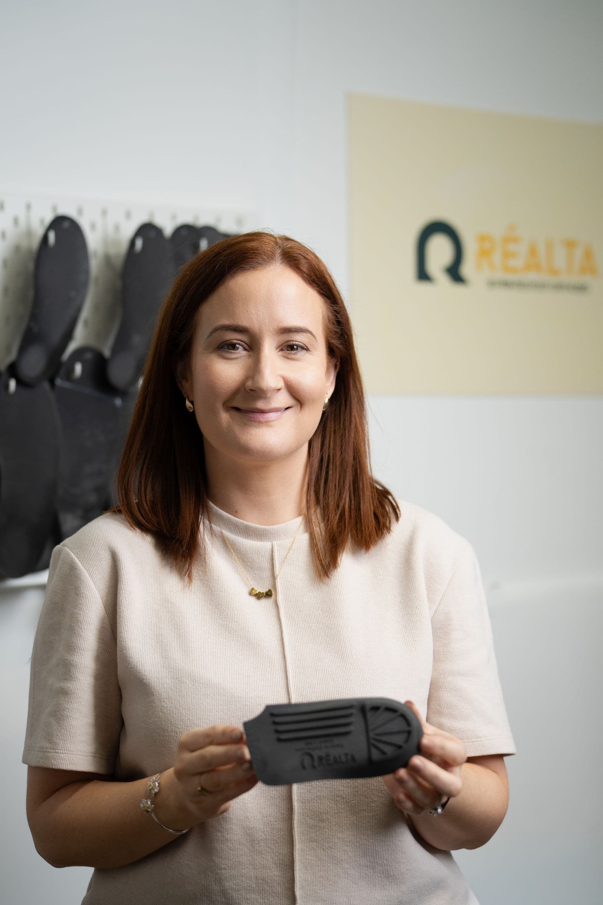 Sharon McMullan holding an orthotic with Réalta sign behind